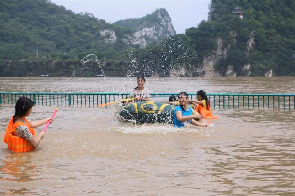 Ở Liễu Châu, Quảng Tây, vì mưa lũ diễn ra vào cuối tuần nên các gia đình tận dụng, cho các cháu đi "công viên nước ngoài trời" miễn phí.