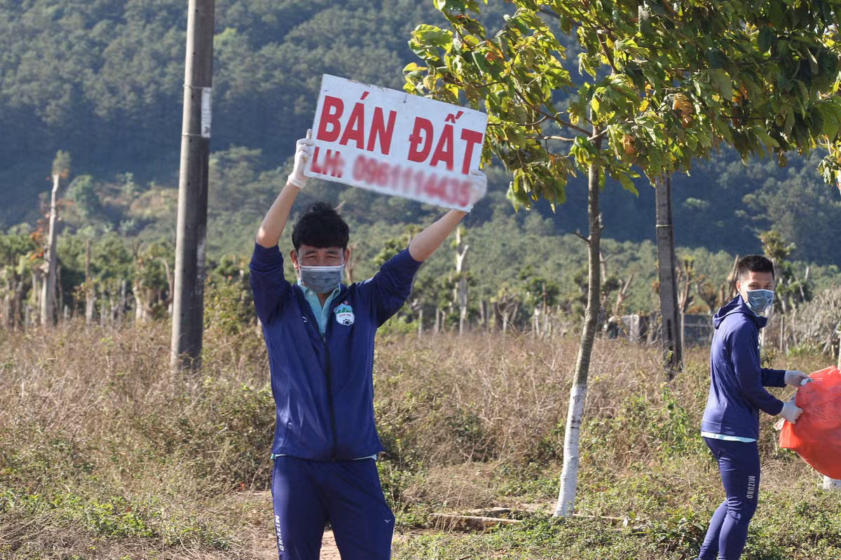 Nam cầu thủ hài hước cầm biểt "bán đất" rêu rao. Có lẽ mục đích của nam cầu thủ là đi nhặt rác, bán đất chứ không phải thăm quan sao?