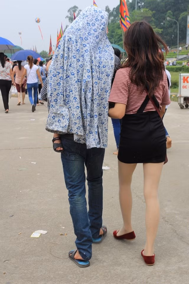 Cô gái trẻ mặc chiếc váy yếm ngắn cũng hòa vào dòng người dâng hương hành lễ.