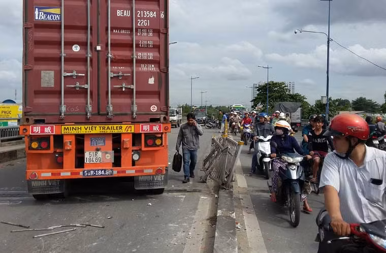 Tại hiện trường, hơn 10m dải phân cách bị húc văng nằm la liệt, chiếc xe máy kẹt cứng dưới gầm và chiếc xe container nằm chắn hết một làn đường làm cho giao thông ùn tắc nghiêm trọng.