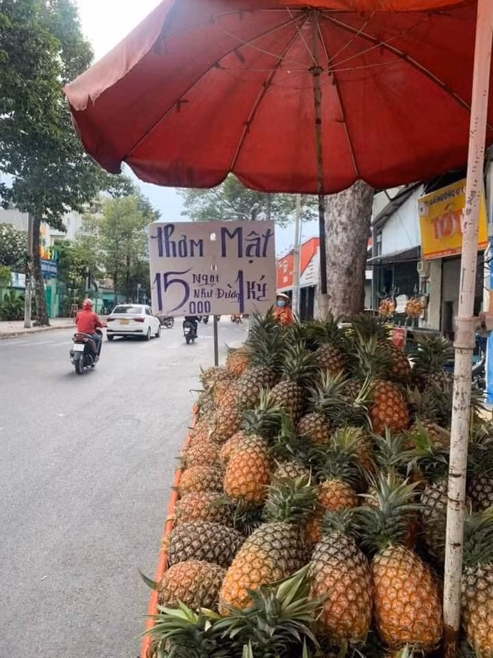Trên tấm biển quảng cáo người bán giới thiệu đây là thơm mật "ngọt như đường" với giá 15k/kg. Dòng quảng cáo đầy gọi mời trên khiến một khách hàng không ngần ngại ghé thử.