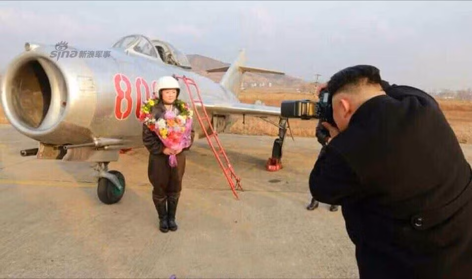 Nhà lãnh đạo Triều Tiên Kim Jong-un chụp ảnh cho nữ phi công tiêm kích của Không quân Triều Tiên bên cạnh chiếc chiến đấu cơ MiG-15. Nguồn ảnh: Sina.