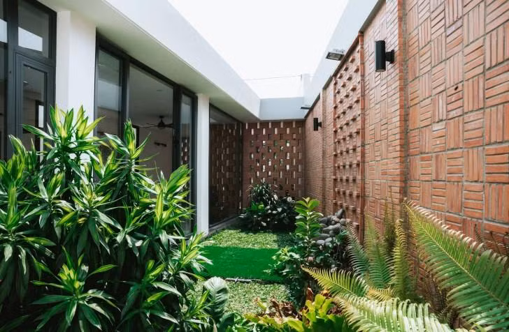 Một khoảng sân vườn xanh mát với nhiều loại cây chính là tận dụng khoảng đất xéo, đồng thời giúp cân đối không gian ngôi nhà.