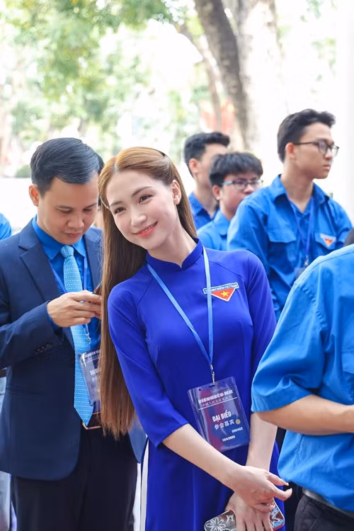 Nữ ca sĩ diện áo dài màu xanh, khoe vẻ rạng rỡ.