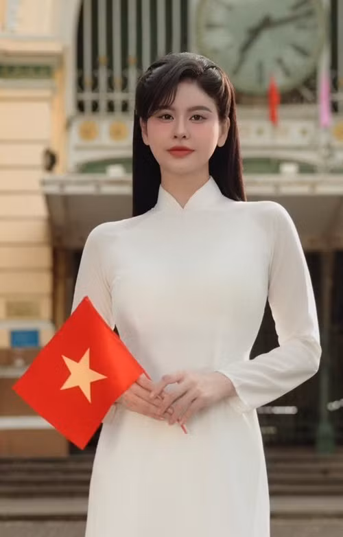 Trương Quỳnh Anh diện áo dài trắng tinh khôi, cầm lá cờ đỏ sao vàng. Ảnh: FB Trương Quỳnh Anh