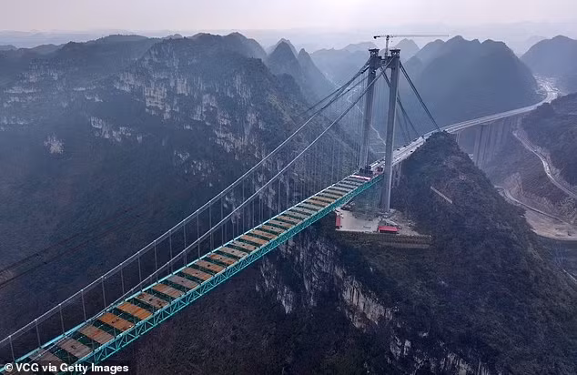 Dự kiến, cây cầu cao nhất thế giới này sẽ được khánh thành vào tháng 6/2025, giúp rút ngắn thời gian di chuyển qua hẻm núi từ hơn một giờ xuống chỉ còn vài phút. Ảnh: VCG/GI.