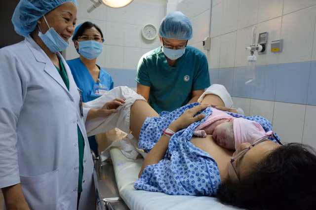 Bác sĩ Nguyễn Thị Quý Khoa đón em bé đầu tiên Mậu Tuất chào đời tại bệnh viện phụ sản Từ Dũ - Ảnh: VŨ THỦY