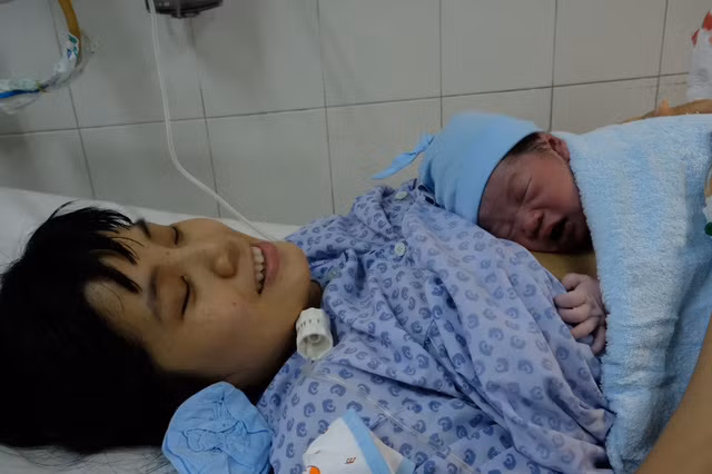 Nụ cười của bà mẹ trẻ Võ Thị Trà My (30 tuổi) giây phút chào đón con ra đời trong đêm giao thừa - Ảnh: VŨ THỦY