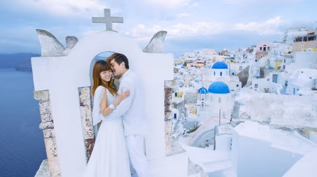 Cặp vợ chồng trẻ đã mua hai bộ váy cưới, trong khi Zhu tham gia khóa học trang điểm và Sim đầu tư một chiếc máy ảnh chuyên nghiệp cũng như học các kỹ năng tự chụp ảnh. Ảnh: Đảo Santorini, Hi Lạp.