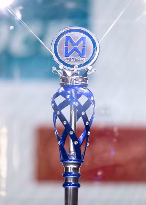 Chiếc quyền trượng Hoa hậu Thế giới Việt Nam 2019 lấy cảm hứng từ những tinh tú tỏa sáng trong dải ngân hà. Quyền trượng mang hình ảnh chiếc vương miện nâng đỡ logo Hoa hậu Thế giới Việt Nam cùng những dải lụa xanh uốn cong mềm mại được điểm xuyết bằng 83 viên đá quý sắc trắng, xanh lấp lánh. Điểm nhấn của chiếc quyền trượng là viên pha lê xanh 35 ly nổi bật. Ảnh: Tiền Phong