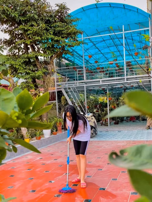 Đỗ Thị Hà mặc đơn giản khi lau dọn sân nhà. Ảnh: FB Đỗ Thị Hà.