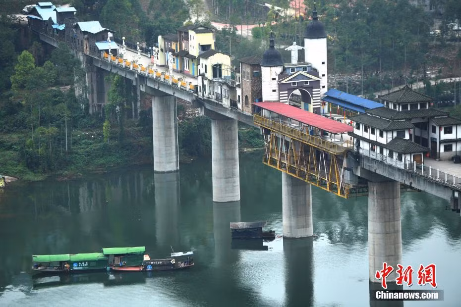 Cây cầu này có độ dài 400 mét, trên cầu là những ngôi nhà đủ màu sắc được xây dựng san sát nhau, chia ra thành từng cụm thuộc thị trấn Hồng Tửu. (Ảnh: Chinanews, IT).