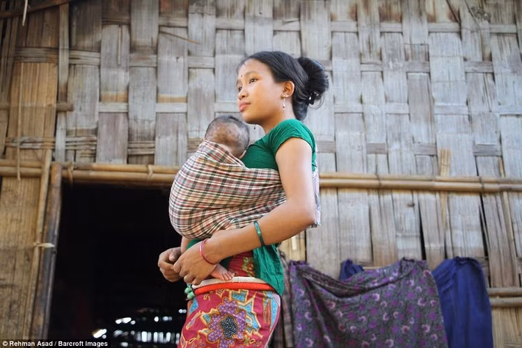 Một người phụ nữ bản địa đang địu con trong mùa lễ hội Kumlang. Người dân bản địa tổ chức lễ hội này để cầu mong mùa màng bội thu trong năm tới.