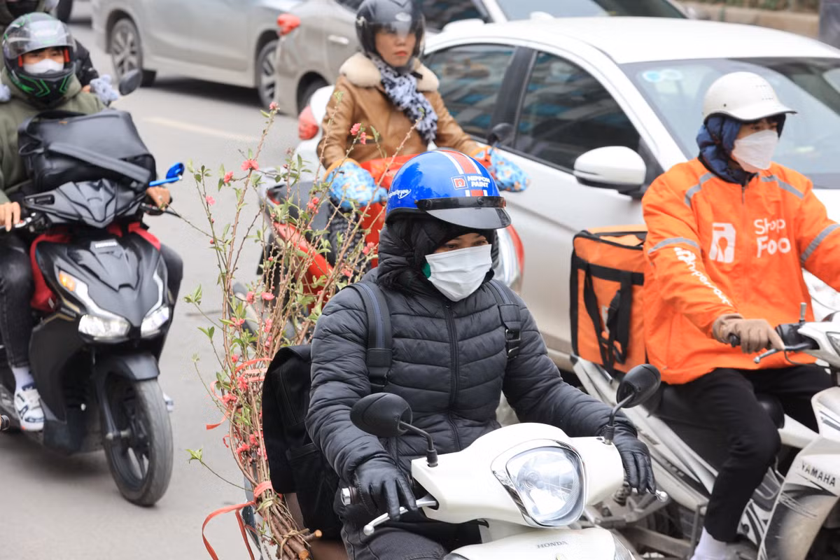 Người dân chở theo quất, cành đào... cồng kềnh khiến việc di chuyển càng thêm khó khăn.