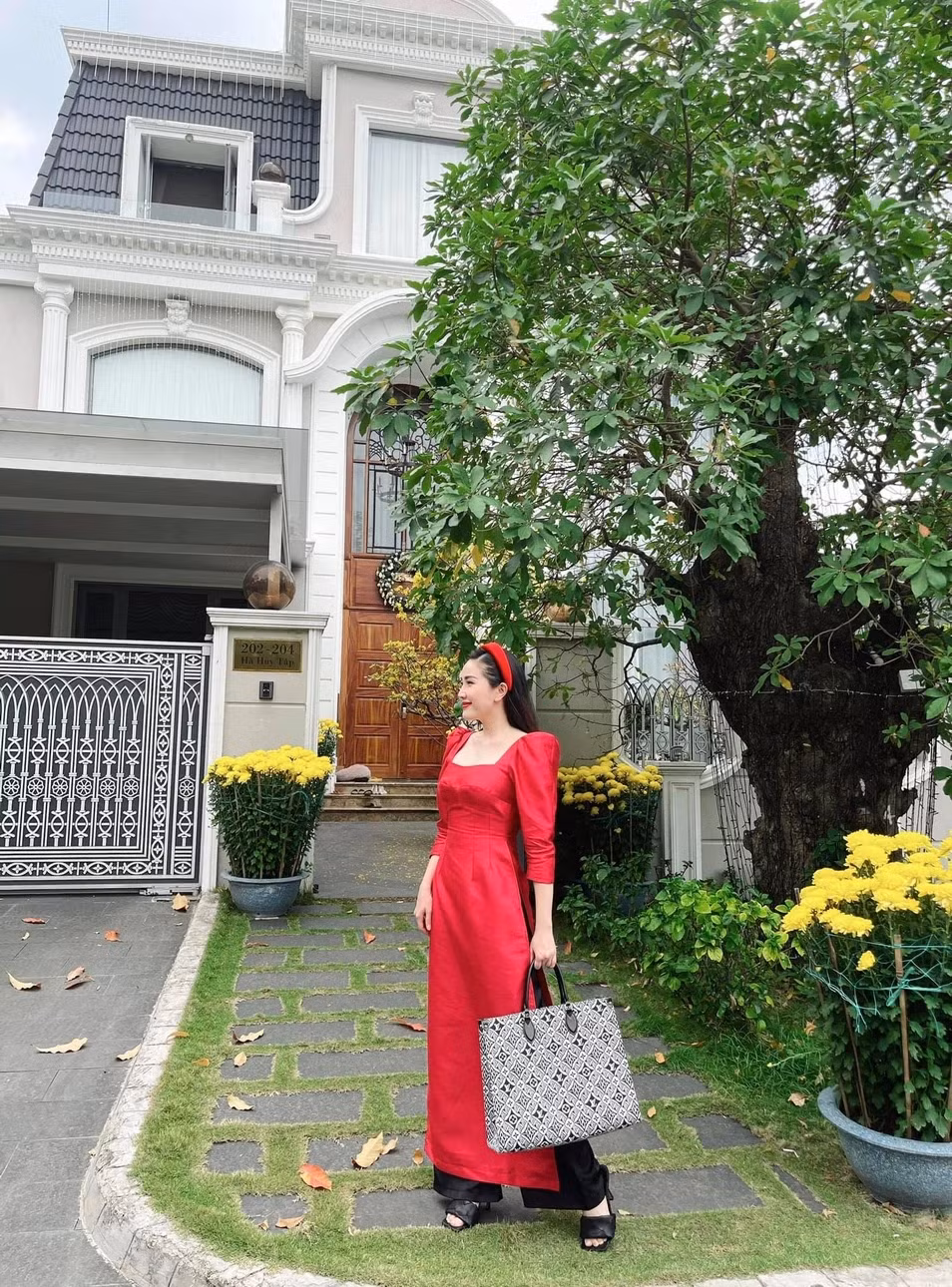 Phía trước ngôi nhà là không gian thoáng đãng, trồng nhiều cây xanh và hoa tươi.