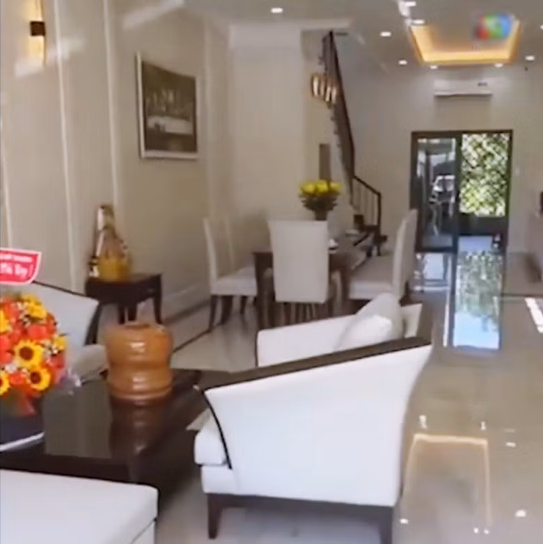 Phòng khách được bài trí sang trọng. Bộ sofa và bàn ghế ăn "tông xoẹt tông" với gam màu sáng.