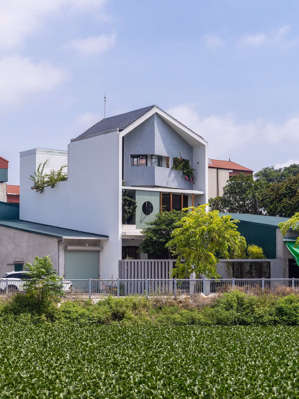 Mặt tiền của ngôi nhà được lấy cảm hứng từ những đường cắt vát trên bề mặt một viên ngọc. Đây là giải pháp giúp đường chéo của khu đất ăn nhập với tổng thể, tạo ra bức tranh về sự thay đổi của ánh sáng vào các thời điểm khác nhau. Ảnh: Triệu Chiến