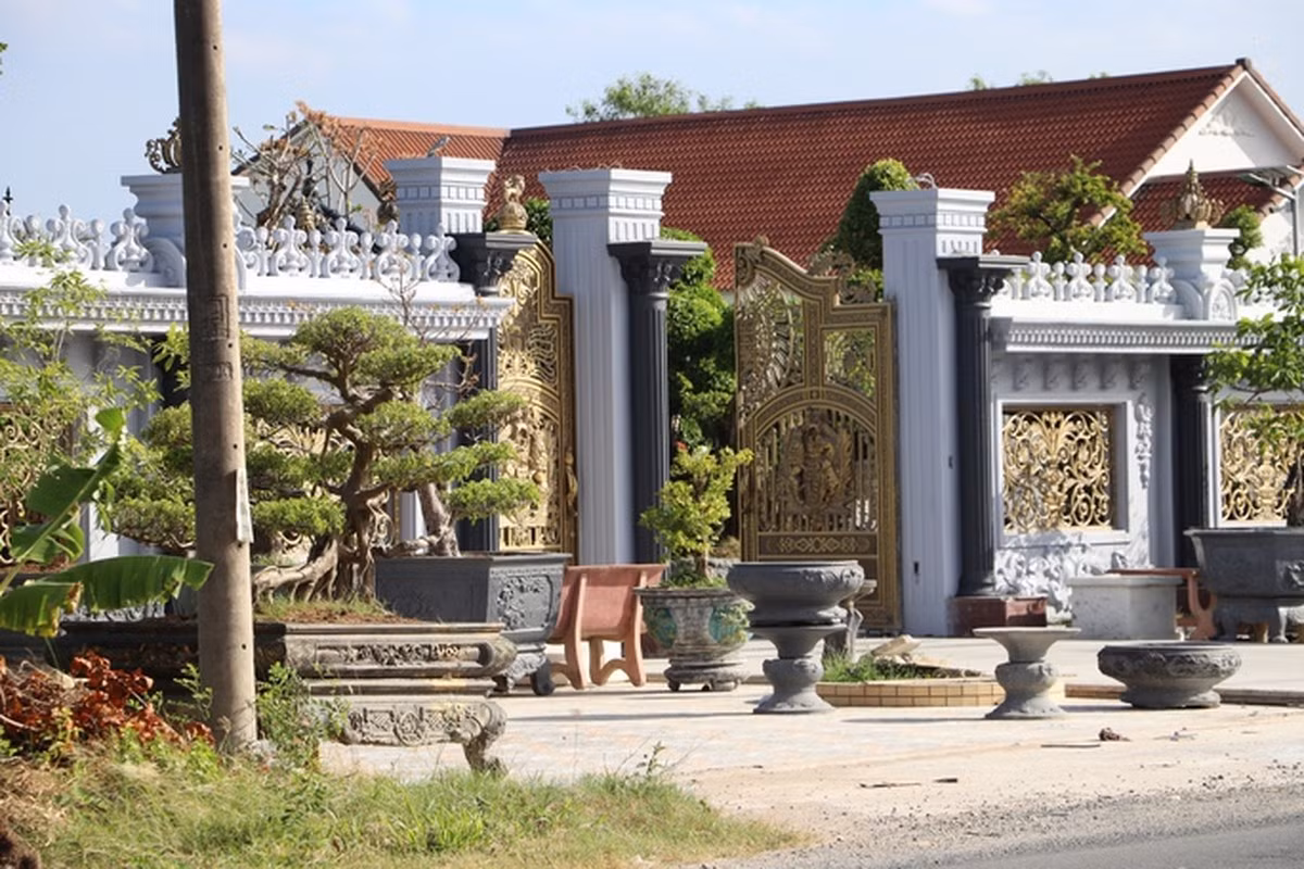 Cổng vào căn biệt thự bề thế với nhiều chậu cây cảnh. Ảnh: Người lao động
