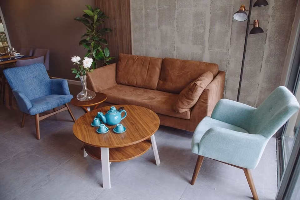 Nhà sử dung gam màu xám chủ đạo, được nhấn nhá bằng những ghế xanh và sofa nâu.
