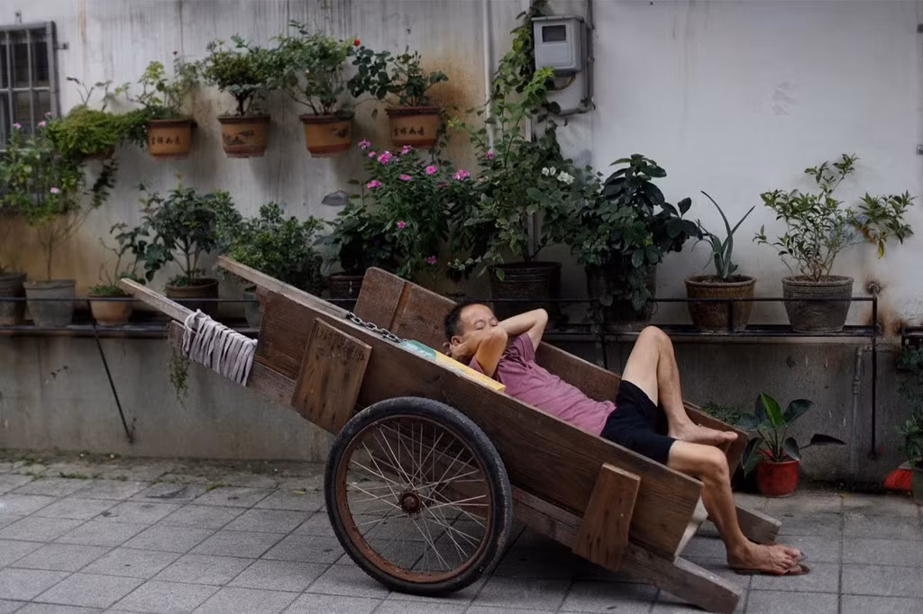 Một người đàn ông ngủ trong chiếc xe đẩy gần chợ ở khu phố truyền thống Việt Tú, Quảng Châu, Trung Quốc, ngày 8/9. Thành phố phát triển mạnh kể từ khi Trung Quốc mở cửa ra thế giới bên ngoài vào cuối những năm 1970, củng cố vị thế là một trong những trung tâm sản xuất quan trọng nhất của đất nước. Sự giàu có đã biến đổi trung tâm thành phố, nơi các tòa nhà chọc trời thống trị đường chân trời. Nổi bật nhất là Tháp Canton cao 604 mét.