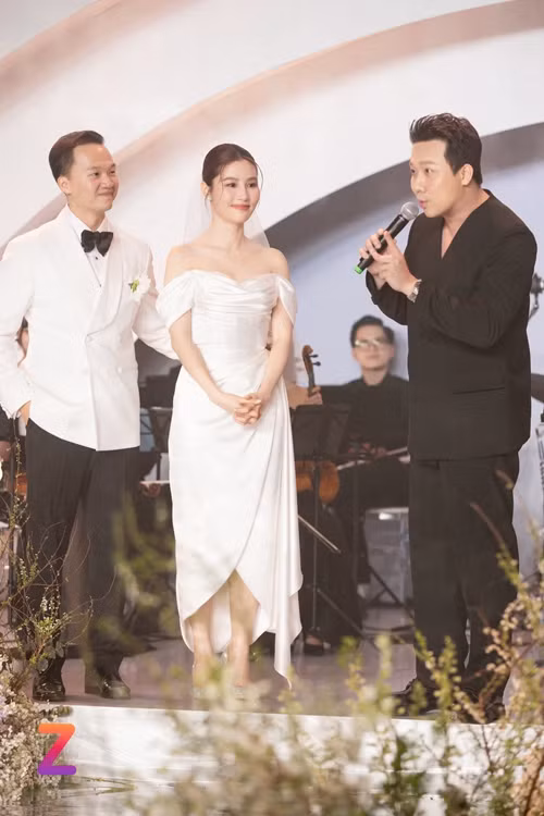 Lên sân khấu phát biểu, Trấn Thành gửi lời chúc mừng đến vợ chồng Diễm My. "Tôi rất xúc động khi nghe hai em nói lời thề nguyện. Tôi rất mừng cho em tôi đã lấy được một người chồng tử tế, tinh tế và đầy kinh tế. Cuộc sống sẽ có lúc hục hặc, bất đồng quan điểm. Những lúc hai đứa khó khăn, sắp buông tay nhau, hãy nghĩ đến ngày hôm nay để đi đến chặng đường còn lại", Znews dẫn lời Trấn Thành. Ảnh: Znews.