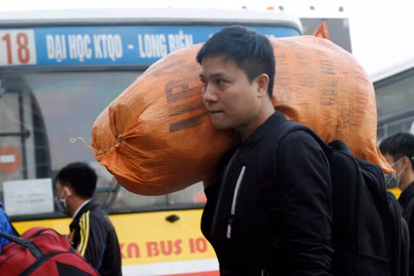 Dù vác bao tải nặng trên vai nhưng nam thanh niên vẫn cố gắng vào bến xe Mỹ Đình mua vé nhanh chóng.