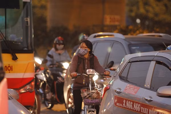Nữ sinh đi xe đạp mắc kẹt trong dòng ô tô.