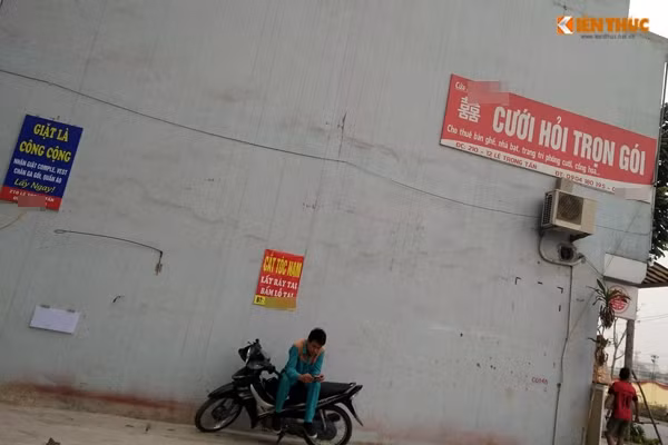 Một cửa hiệu cung cấp dịch vụ cưới hỏi treo thêm một bảng hiệu khác ngay bên cạnh tường nhà.