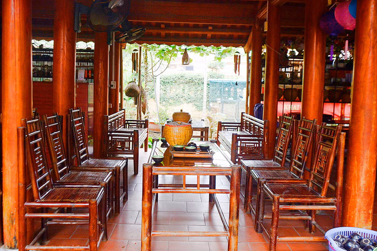 Bên phải ngôi nhà 5 gian là bộ bàn ghế thiết kế kiểu cổ, nhưng sáng bóng với bộ ấm chén pha trà đặt trên khay làm bằng tre nứa.