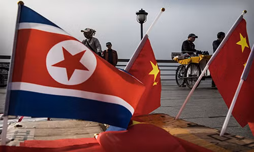 Người bán hàng Trung Quốc bán những lá cờ Trung Quốc và Triều Tiên ở lối đi cạnh sông Áp Lục, tại địa phận thành phố Đan Đông, ngày 24/5/2017.