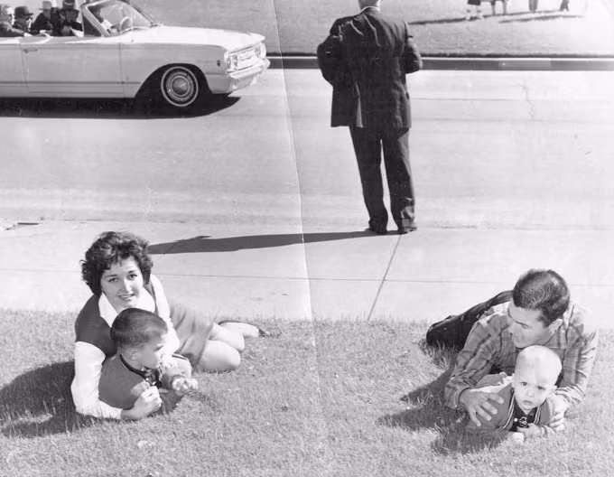 Bill và Gayle Newman nằm xuống đất và che chắn cho con của họ, chỉ vài giây sau khi Tổng thống Kennedy bị bắn. Ảnh: ATI.