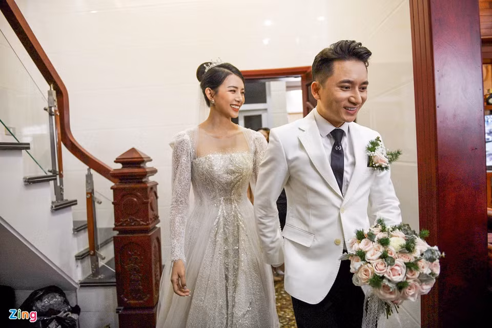 Sau thánh lễ hôn phối diễn ra tại nhà thờ xứ Vạn Phần, lễ cưới chính thức của nhạc sĩ Phan Mạnh Quỳnh và cô dâu Huỳnh Khánh Vy tổ chức tại quảng trường vào ngày 17/4. Trước giờ G, chú rể dắt tay người bạn đời bước ra từ nhà. Nam nhạc sĩ diện suit trắng lịch lãm. Khánh Vy gợi cảm trong bộ đầm cưới cúp ngực.