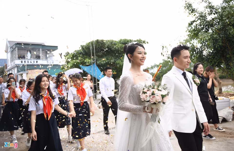 Nhiều người dân ở hai bên đường chăm chú theo dõi lễ cưới của cặp đôi Phan Mạnh Quỳnh - Khánh Vy. Theo thông báo từ người nhà, ngoài hôn lễ ở Nghệ An, cặp đôi sẽ tổ chức tại TP Nha Trang (Khánh Hòa) - quê Khánh Vy và TP.HCM trong thời gian tới.