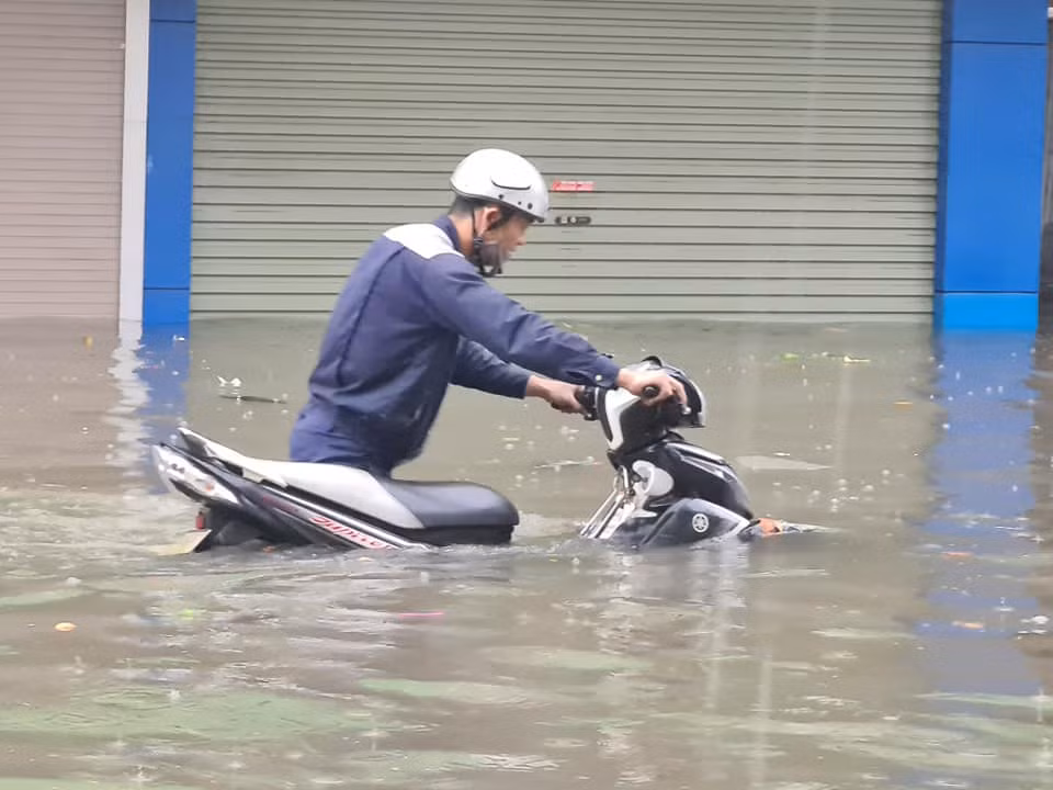 Những người cố gắng ra khỏi nhà tới nơi làm việc, gặp phải "biển nước" khiến nhiều xe bị chết máy. Dù để trên vỉa hè, những chiếc xe máy vẫn ngập nửa bánh xe. (Ảnh: MXH) 