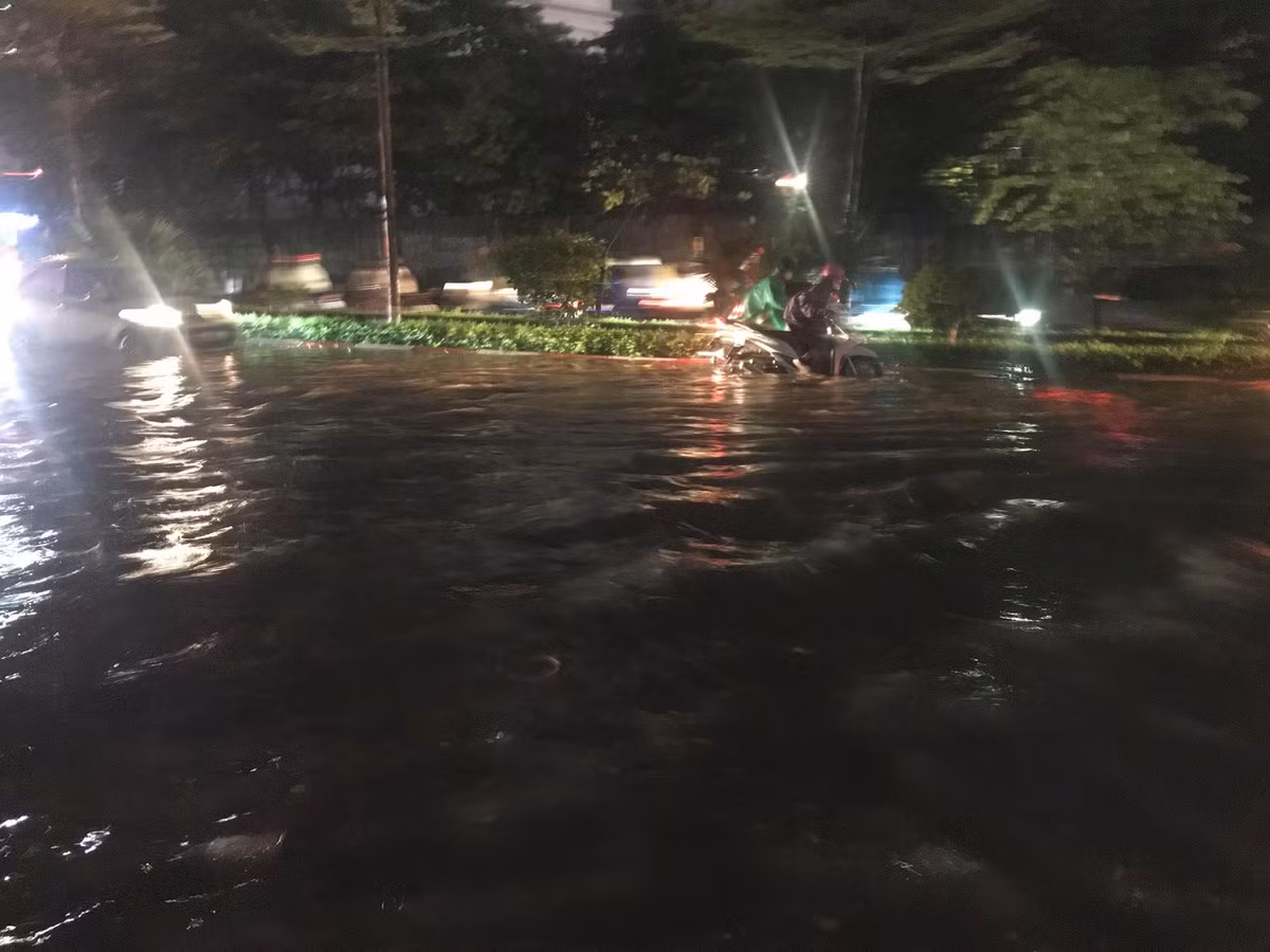 Đường Trần Thái Tông (Cầu Giấy, Hà Nội) sau gần 1 tiếng mưa to đã bị ngập úng cục bộ, xe máy, ô tô di chuyển qua đây gặp khó khăn.