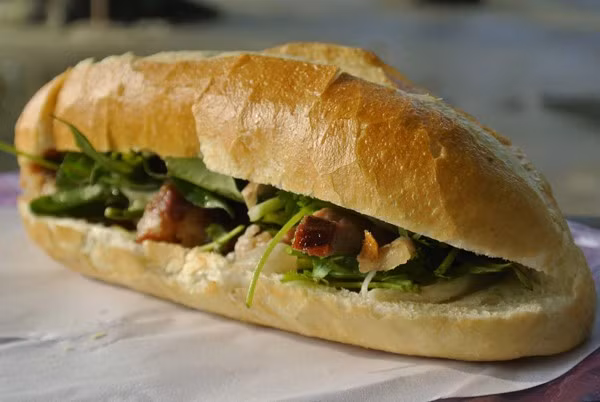  Bánh mì Bà Lan - 62 Trưng Nữ Vương (gần khúc giao với đường Trần Phú). Quán bán buổi tối đến khuya. Bánh mì tại lò nóng hổi, giòn xốp. Khách lúc nào cũng đông nghịt, mua một ổ bánh mì khách phải xếp hàng và đứng chờ khá lâu. Giá: 10-15.000đ/chiếc. (Ảnh: dichvudulichdanang.com).