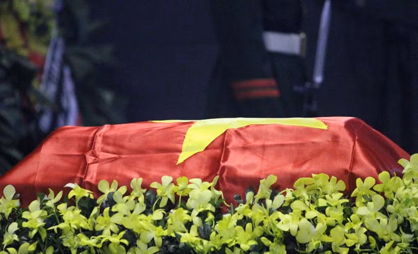 Thi hài anh được phủ lá cờ quyết thắng.