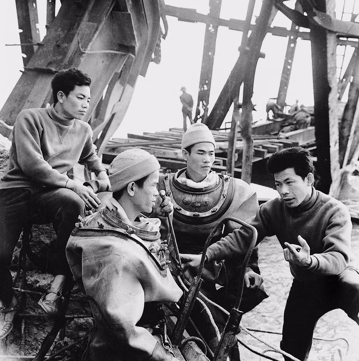 Nhóm công nhân hội ý bàn kế hoạch sửa chữa cầu Hàm Rồng sau khi nơi này bị trúng bom năm 1973.