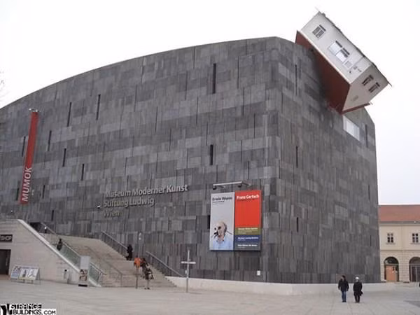 Ngôi nhà Tấn công (Áo). Bảo tàng Moderner Kunst được thiết kế bởi nghệ sỹ Erwin Wurm và là bảo tàng mỹ thuật lớn nhất nước Áo, với hình ảnh một ngôi nhà nhỏ lao vào mái tòa nhà.