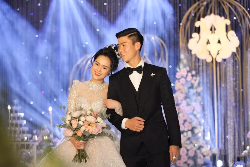 Váy cưới của cô dâu Quỳnh Anh diện trong ngày trọng đại có giá hơn 1 tỷ đồng. Phần cổ áo đính kết 1.000 viên Swarovski nhập từ Áo, tổng số hạt đá pha lê đính trên thân váy là 8.000 viên làm chiếc váy thêm phần đắt đỏ.