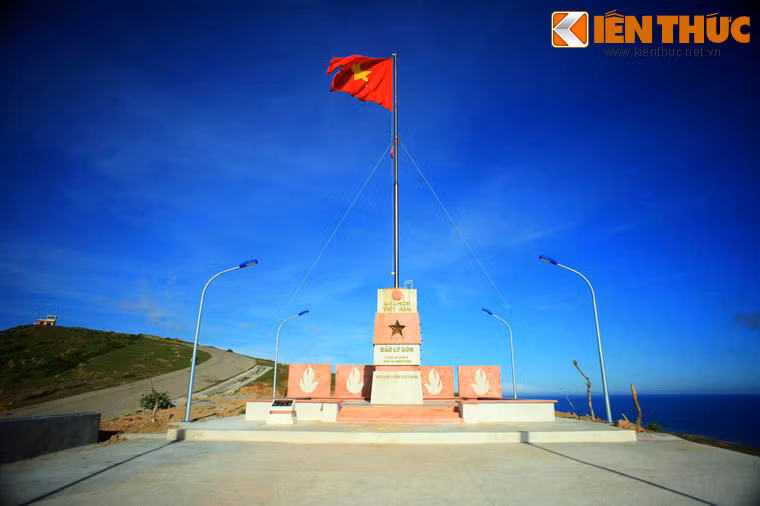 Cột cờ được xây dựng năm 2013 theo thiết kế cột mốc chủ quyền biển đảo Việt Nam với chiều cao 20m, diện tích lá cờ 4 x 6 mét, hướng ra Hoàng Sa. Mặt chính trên đài ghi rõ chủ quyền, kinh độ, vĩ độ của đảo Lý Sơn.Phần thân màu trắng được bọc ngang mang sắc đỏ của Quốc kỳ, như biểu tượng xương máu cha ông ôm lấy và bảo vệ từng tấc đất, từng dấu mốc ngoài đảo xa.