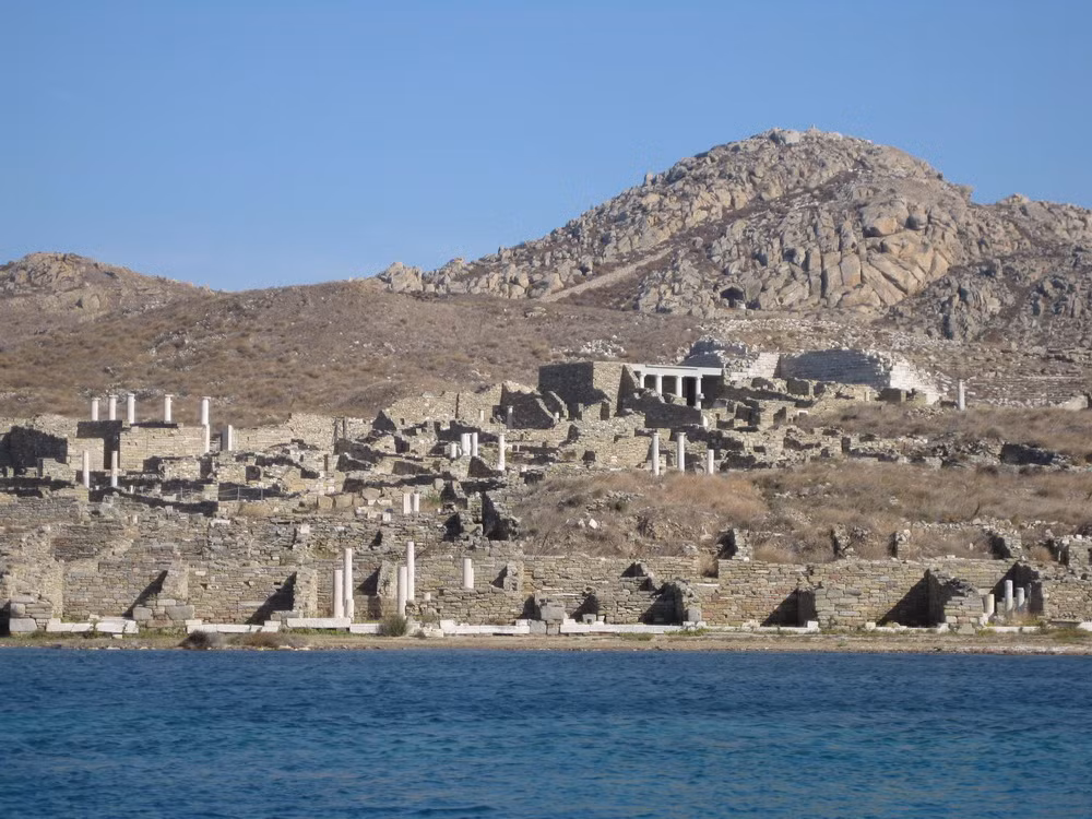 Nằm trên đảo Delos ở quần đảo Cyclades của Hy Lạp, thành phố cổ Delos- trung tâm buôn bán nô lệ lớn nhất Địa Trung Hải thời cổ đại và là vùng đất cấm tử đầu tiên trên thế giới là một trong những địa điểm khảo cổ quan trọng nhất ở Hy Lạp và khu vực Địa Trung Hải..