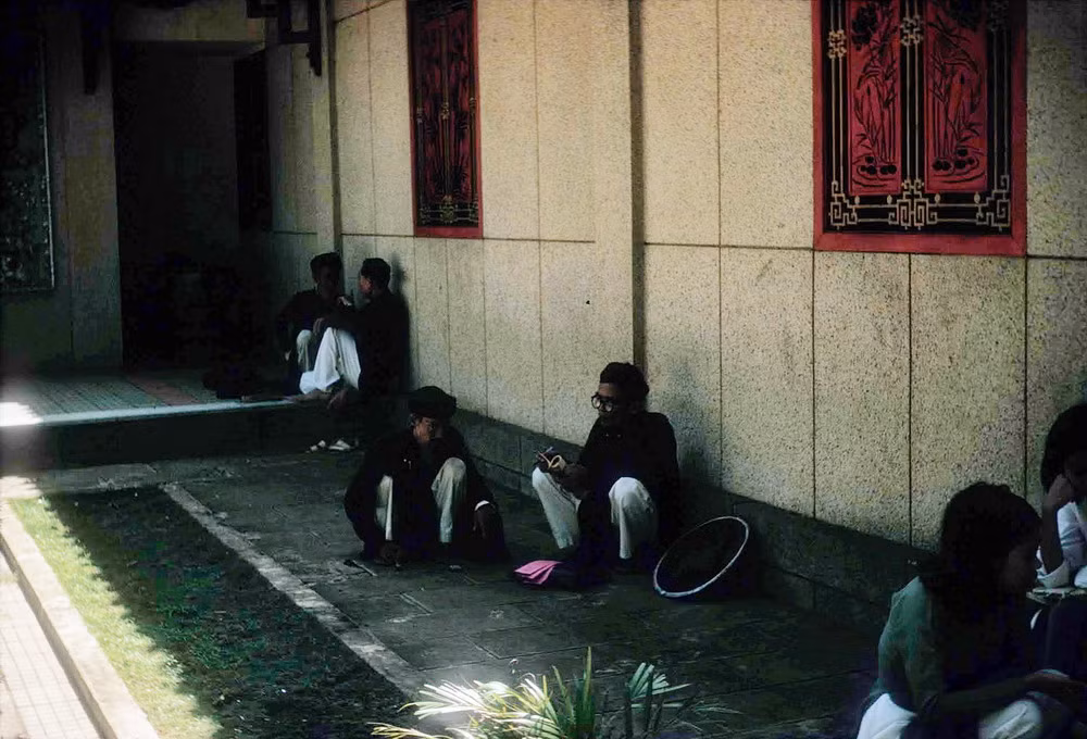Người dân tránh nắng trong bóng râm của công trình.