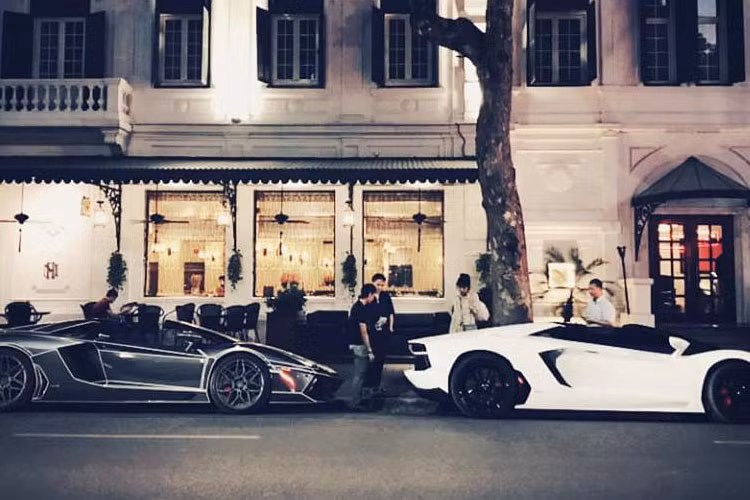 Đỗ cùng siêu xe Lamborghini Aventador mui trần màu trắng từng thuộc sở hữu của đại gia Cường Đô la trên đường phố Hà Nội còn có 1 "người bạn siêu bò mui trần" mang bộ áo đen crôm.
