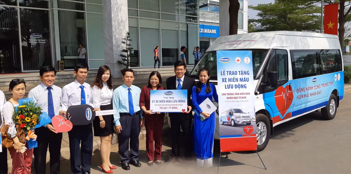 Các đại diện của Vinamilk và Trung tâm hiến máu nhân đạo TP.HCM bên cạnh xe hiến máu lưu động – món quà ý nghĩa mà Vinamilk trao tặng.