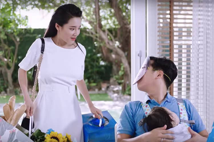 Giữ đúng lời hứa, trong một video khác, Trường Giang và Nhã Phương xuất hiện trong vai một cặp vợ chồng có con gái nhỏ. Trong phân cảnh nhân viên giao hàng tới và hỏi vợ chồng Trường Giang: "Chị Phương mới sinh con gái xong nè", Trường Giang thắc mắc: "Sao biết vậy?". Ảnh: Yan