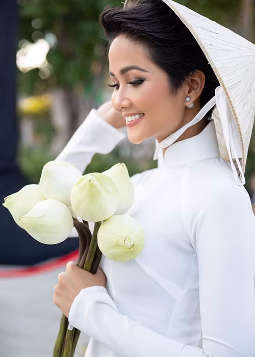 Xuất hiện tại sự kiện, người đẹp chọn phong cách dịu dàng, thanh lịch trong tà áo dài trắng, cùng nón lá và búp sen.