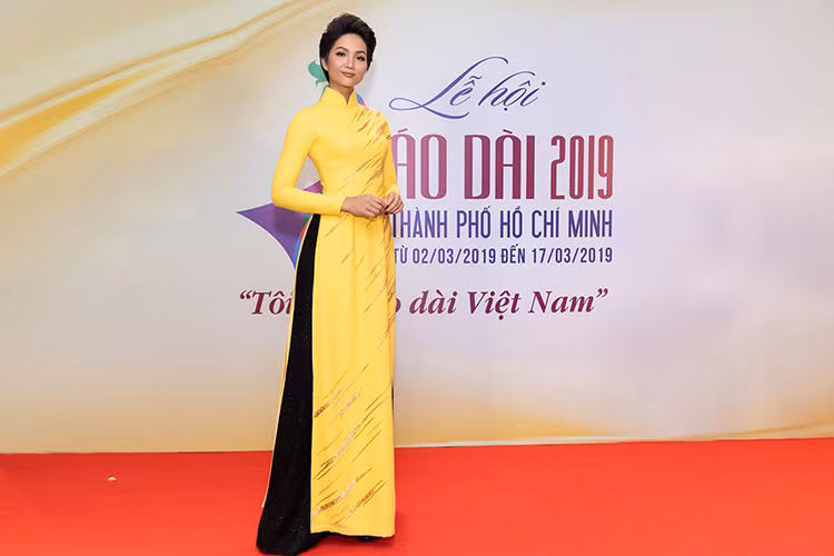 H'hen Niê diện tà áo dài vàng đơn giản kết hợp cùng quần đen đậm chất Sài Gòn xưa.