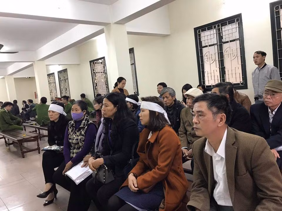 Người thân của các nạn nhân đeo khăn tang đến tòa.