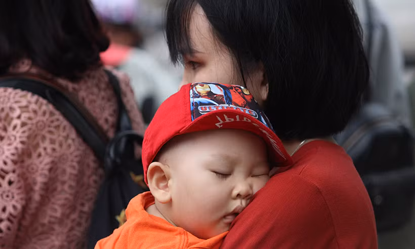 Một số em nhỏ do mệt mỏi nên ngủ thiếp trên vai mẹ.